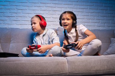 Oyun konsoluyla oyun oynayan çocuklar