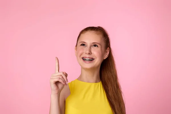 Glad upphetsad blond kvinna indikerar finger tomt utrymme — Stockfoto
