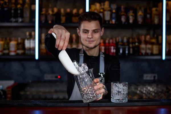 Barman wkłada kostki lodu do szklanki. — Zdjęcie stockowe