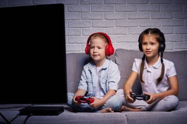 Oyun konsoluyla oyun oynayan çocuklar