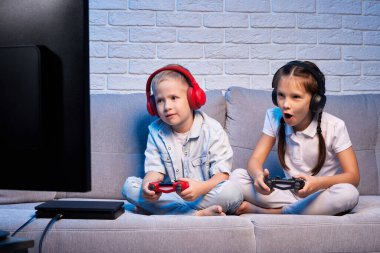 Oyun konsoluyla oyun oynayan çocuklar