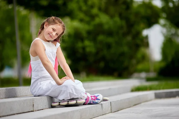 Nettes kleines Mädchen auf Rollschuhen im Park. — Stockfoto