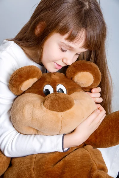 Meisje knuffelen haar teddybeer — Stockfoto