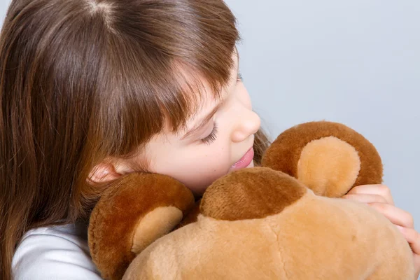 Meisje knuffelen haar teddybeer — Stockfoto