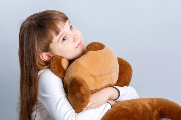 Dívka s úsměvem a objal její medvídek — Stock fotografie