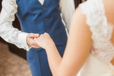 Düğün çifti el ele tutuşuyor.