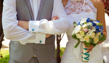 Düğün çifti el ele tutuşuyor.