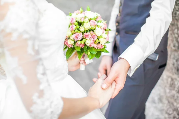 Hochzeitspaar hält Händchen — Stockfoto
