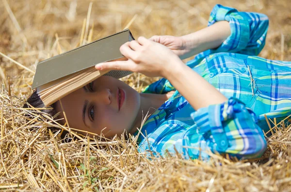 Meisje in tarwe houden boek — Stockfoto