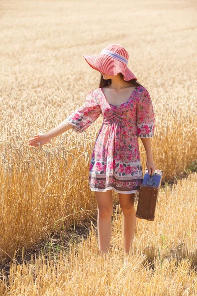 Meisje in hoed op tarweveld — Stockfoto