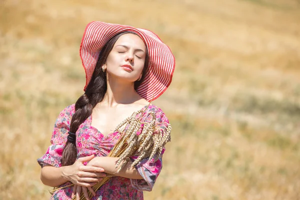 Girl in hat on wheat field — Stock Photo, Image