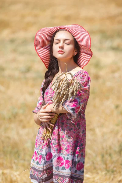 Girl in hat on wheat field — Stock Photo, Image