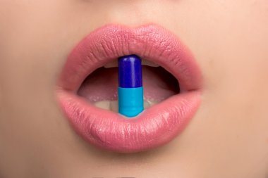 Woman mouth with pill