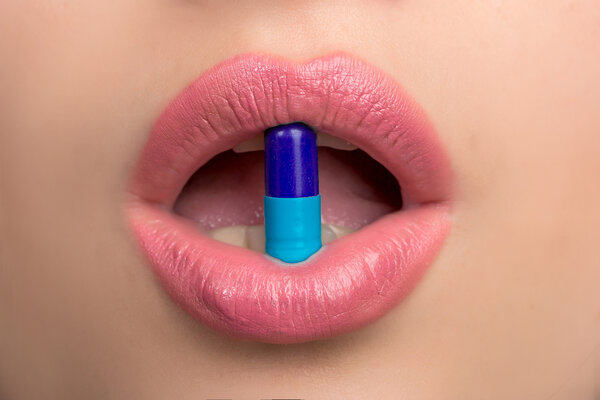 Женский рот с таблетками
