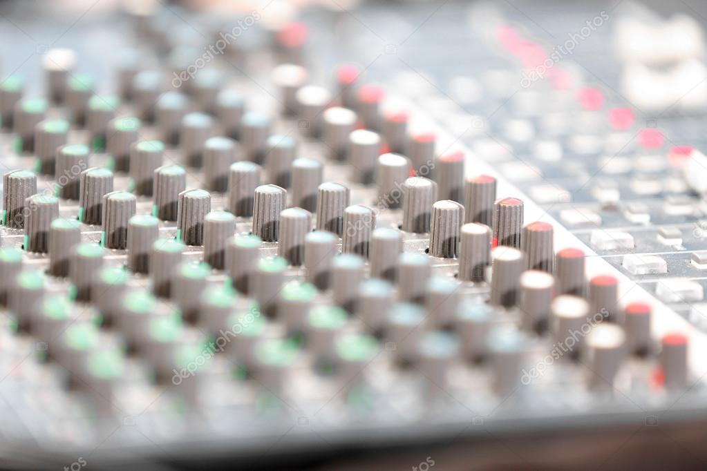 An expert adjusting audio mixing console 