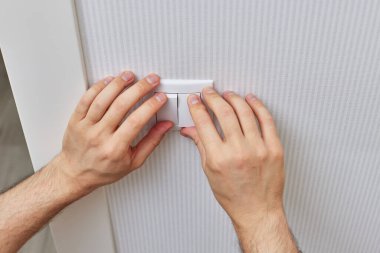 male hands of electrician installing electric light switch at home. Replacing.