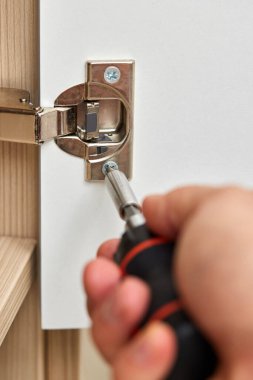 Erkek eli dolapta ve vida kapı menteşesi evde, yakın çekim