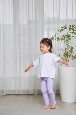 Sağlıklı yaşam tarzı ve fiziksel gelişim için egzersiz yapan küçük bir kız.