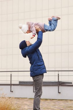 Baba ve kızı neşeli bir anın tadını çıkarıyor, aile sevgisini ve bağlantısını gösteriyor.