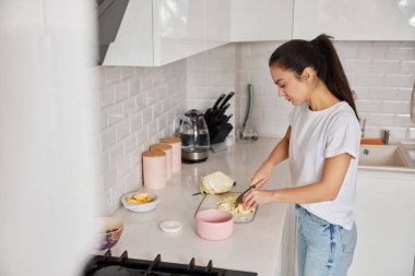 Kesme tahtasında lahana doğrayan bir kadın, evde sağlıklı bir yemek hazırlıyor.