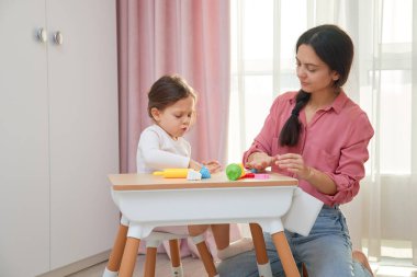 Anne ve kızı evde kil modelliği yaparak yaratıcı zaman geçirmeyi seviyorlar.