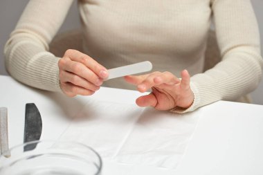 Kadınların elleri tırnaklarını törpülüyor, kişisel bakım ve güzellik temizliği yapıyor.