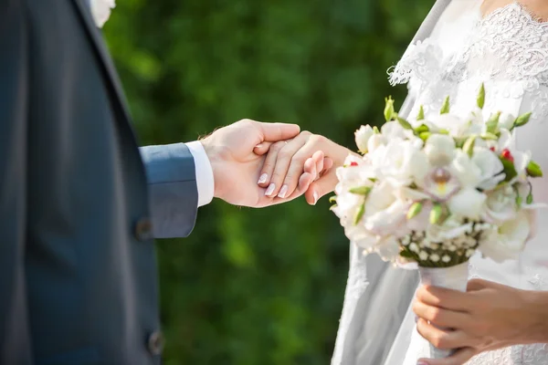 Bröllopspar som håller varandra i handen — Stockfoto