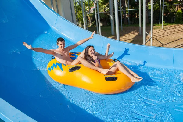 Couple sliding down a water slide — Stock Photo, Image