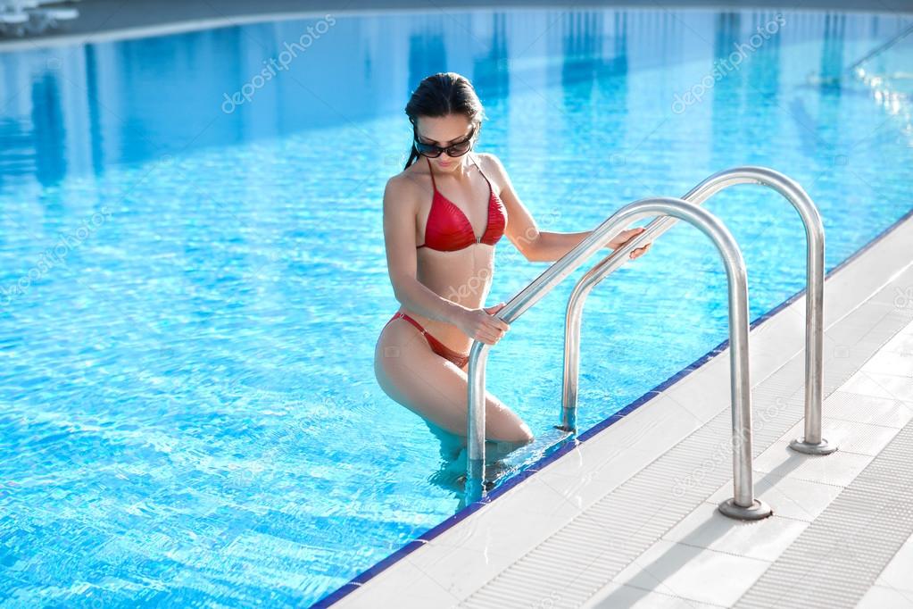 woman posing outdoor in summer  in bikini on pool