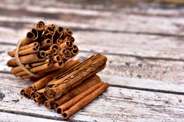 Isolate bunch of cinnamon on a wooden table