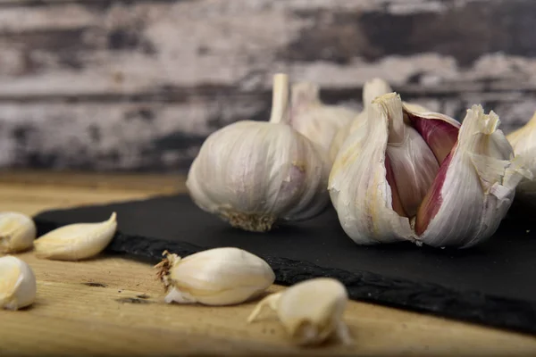 Organic white garlic on a black slate plate