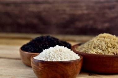 Tahta kaselerde organik beyaz kahverengi ve siyah pirinç.