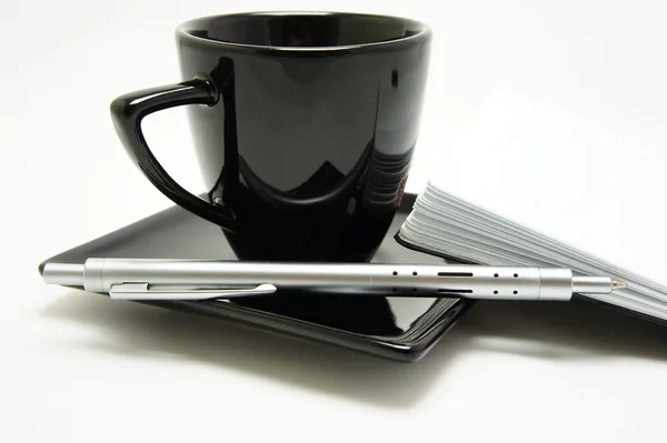 Pluma de metal con taza y cuaderno Imagen de stock