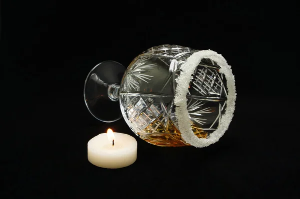 Crystal glass with sugar residues of alcohol and candle. — Stock Photo, Image