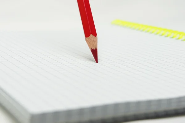 Red pencil standing on notebook. Stock Image