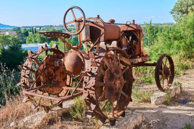 Eskiden pirinç tarlalarında kullanılan paslı bir traktör.