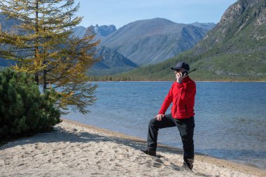 Dağlarda uydu telefonundan konuşan bir adam.