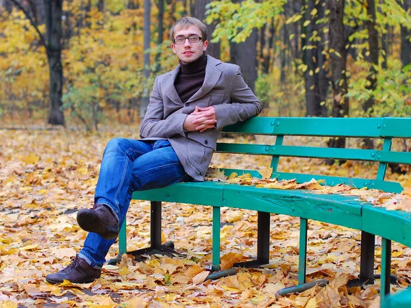 Park adam bir salonu sonbaharda oturur.