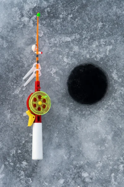 La caña para la pesca de invierno se encuentra cerca de un agujero —  Fotos de Stock