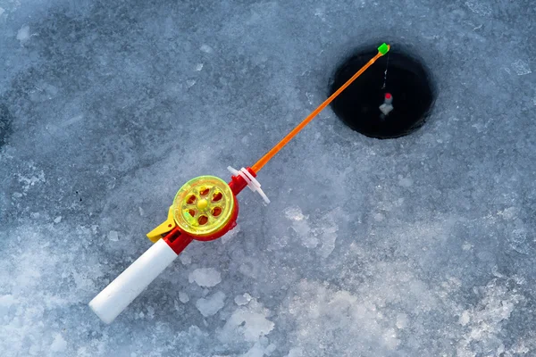 De staaf voor winter visserij ligt in de buurt van een gat — Stockfoto