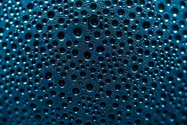Вода падає на блакитне скло — стокове фото