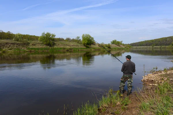 Pescatore con una canna da pesca sul fiume — Foto Stock