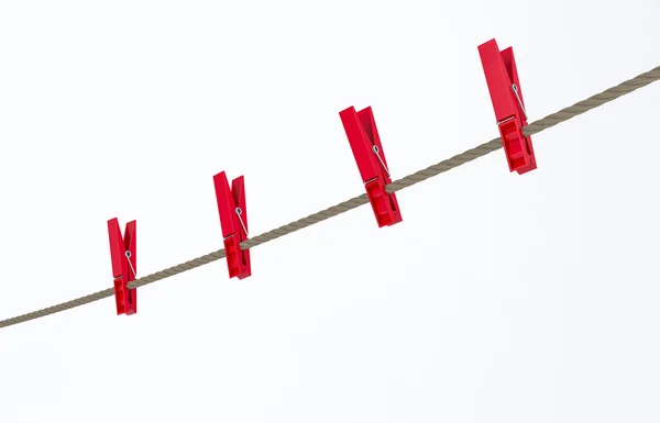 Red clothes pegs on wire — Stock Photo, Image