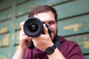 Şehirde elinde dijital kamera olan, fotoğraf çeken, yaratıcı, sanatçı konsepti olan genç ve güzel bir adamın yarı uzunluğunda.