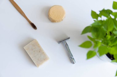 Sıfır atık ürün, başlığı kapat. Bambu diş fırçası, sağlam şampuan, metal jilet ve sağlam el sabunu. Beyaz arka planda sürdürülebilir banyo ürünleri.