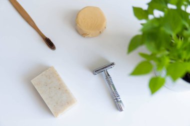Sıfır atık ürün, başlığı kapat. Bambu diş fırçası, sağlam şampuan, metal jilet ve sağlam el sabunu. Beyaz arka planda sürdürülebilir banyo ürünleri.