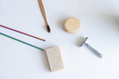 Sıfır atık ürün, başlığı kapat. Bambu diş fırçası, sağlam şampuan, metal jilet ve sağlam el sabunu. Beyaz arka planda sürdürülebilir banyo ürünleri.