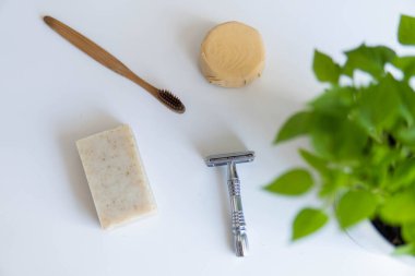 Sıfır atık ürün, başlığı kapat. Bambu diş fırçası, sağlam şampuan, metal jilet ve sağlam el sabunu. Beyaz arka planda sürdürülebilir banyo ürünleri.