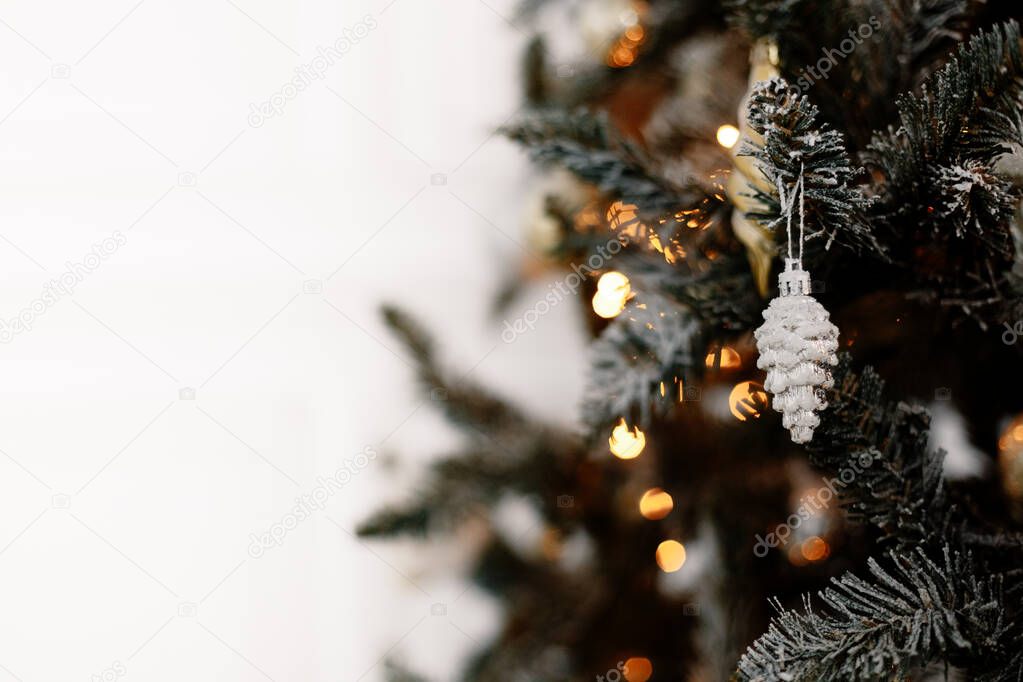 A toy in the form of a silver cone on a Christmas tree. New Year's and Christmas. Wallpaper with place for text. Isolated on white