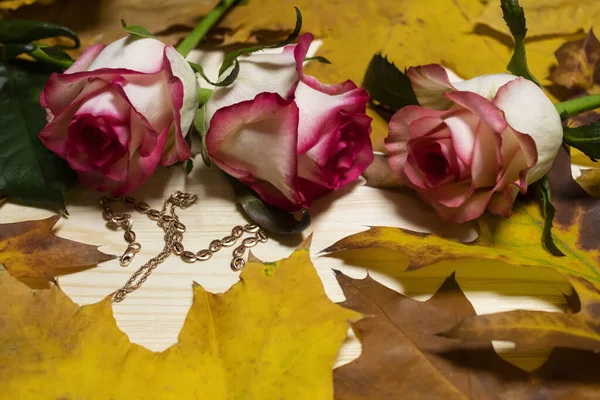 Herbstblätter Drei Rosen Goldschmuckketten Und Armbänder Liegen Auf Einem Hölzernen — Stockfoto